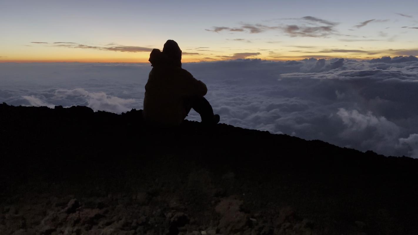 Connor on top of Mt. Fuji as the sun slowly begins to rise on the horizon