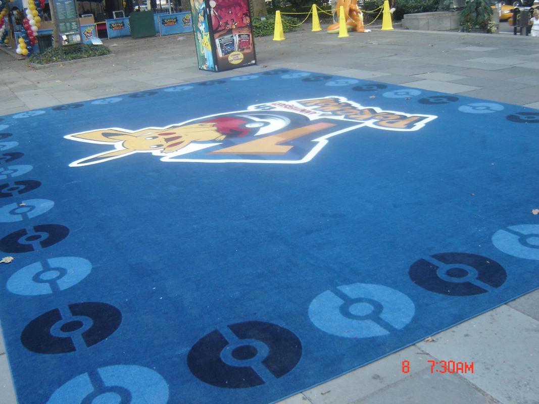 A large blue mat with the Pokémon 10th anniversary logo