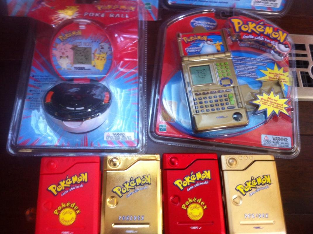A picture of the “Gold Vac-Metal Pokedex”, an unreleased prototype of the original Pokédex. Also pictured are toys Chris worked on, including the Poké Ball, and the Pokédex Deluxe