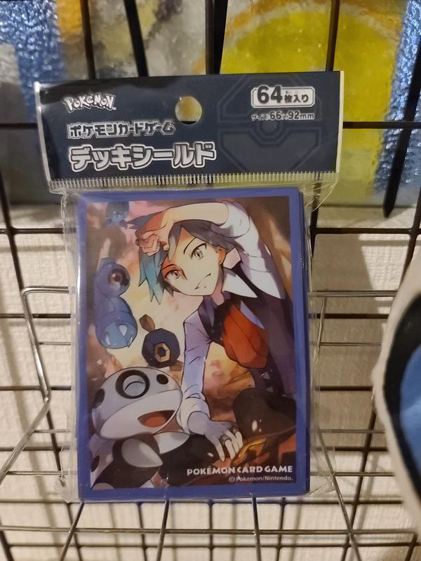 My absolute favourite item has to be the 64 card sleeve pack titled ‘Steven's Holiday’, featuring Hoenn Trainer Steven Stone and an assortment of cavern Pokémon with the goshdarned happiest Aron I've ever seen right in front. Look at it! It's beside itself with joy upon discovering a valuable gem in the rocks!