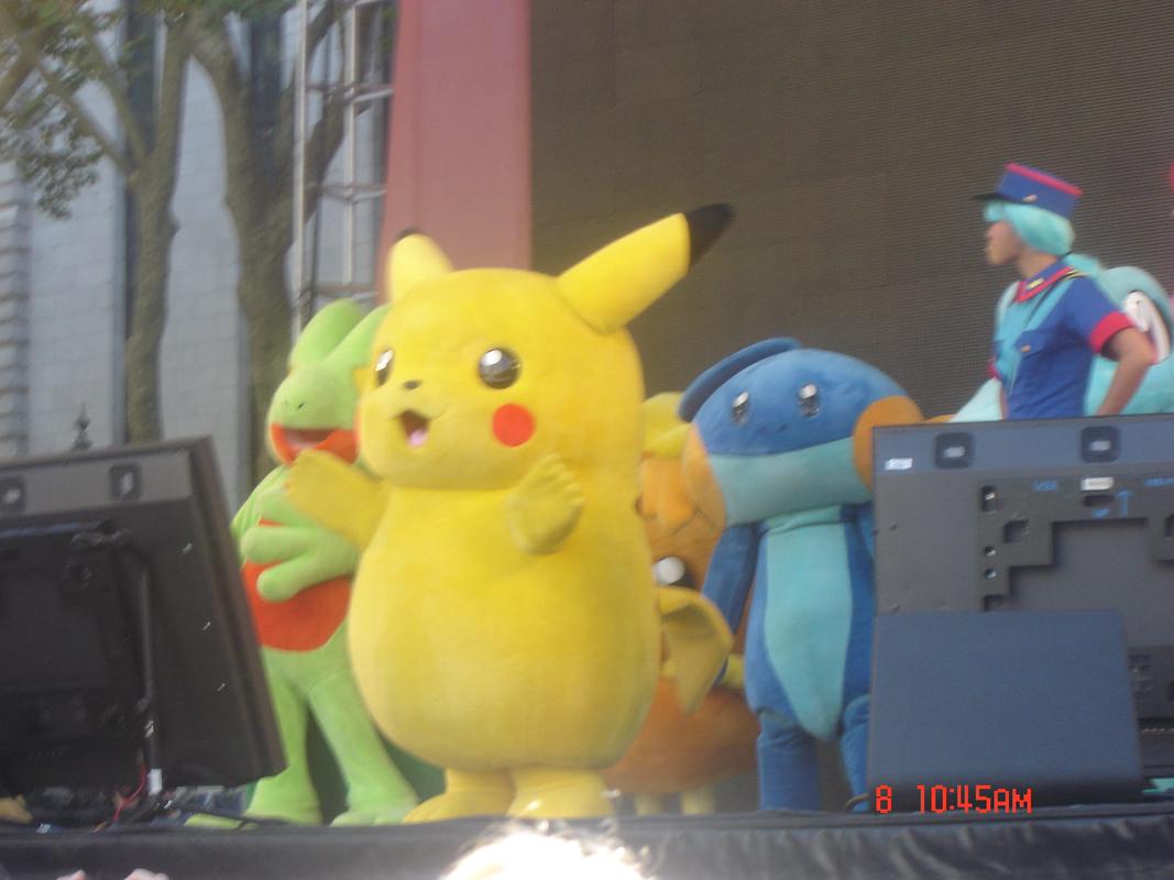 Treecko, Pikachu, Mudkip, and Totodile take to the stage, with what appears to be an Officer Jenny cosplayer